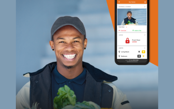 Image of a doorbell camera showing a man smiling and a phone with the alarm.com app showing the same camera feed.